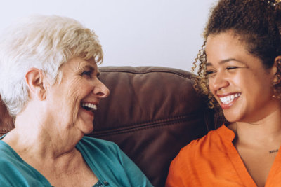 senior woman smiling and her caregiver